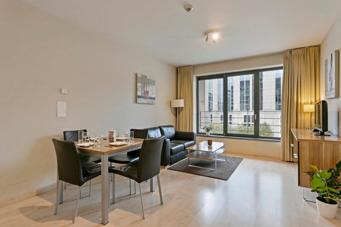 spacious living room and dining table in studio apartment brussels city