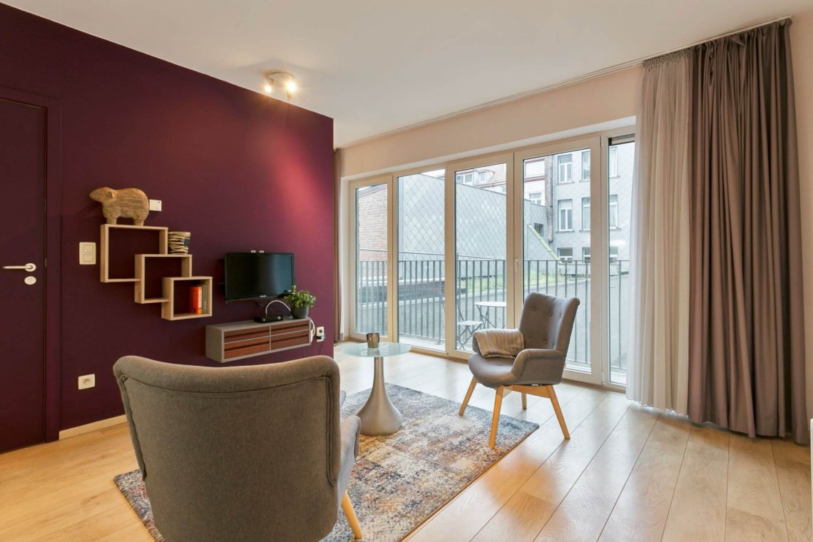 living room of serviced studio apartment with cable television and natural light