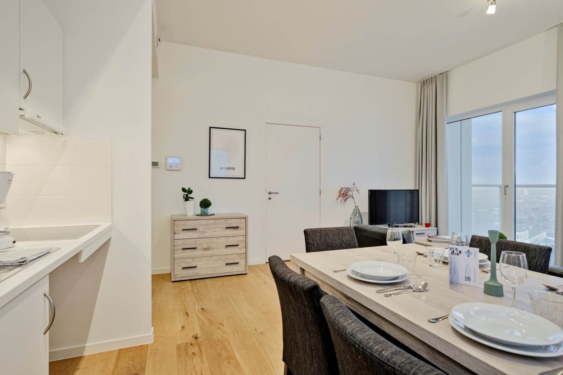 dining table and living room with cable television in bbf serviced apartment antwerp