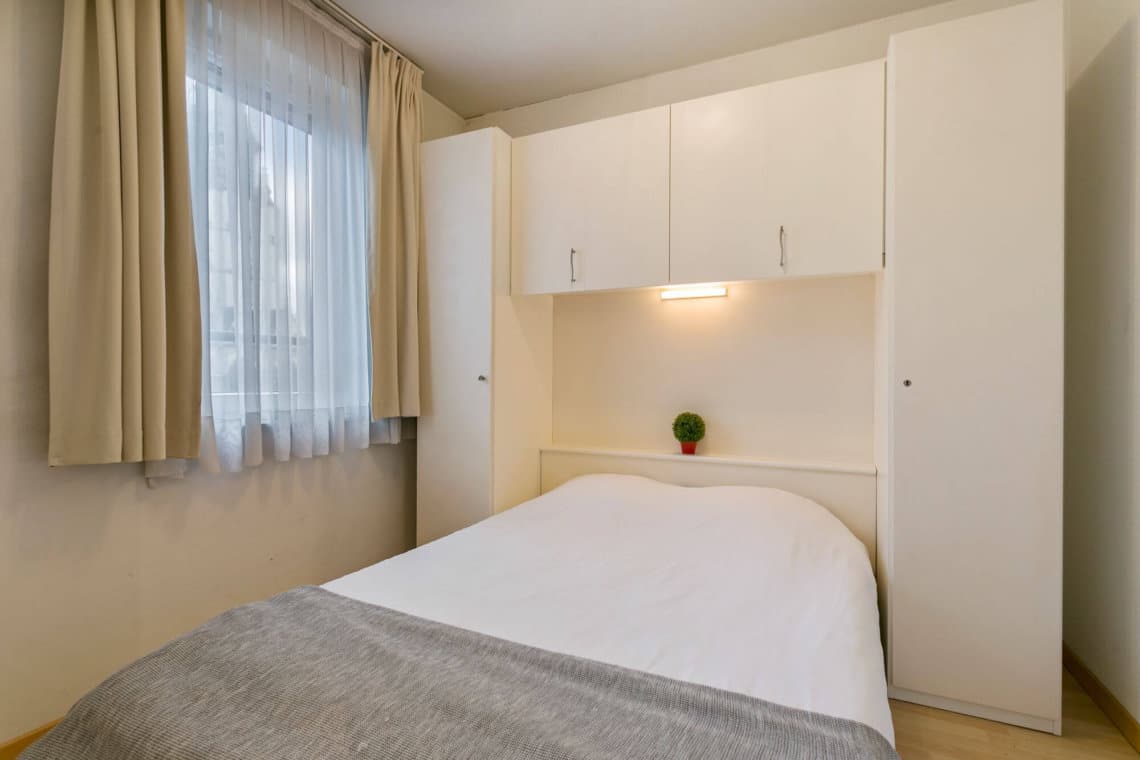 double bed with wardrobe storage and view onto church in sablon brussels