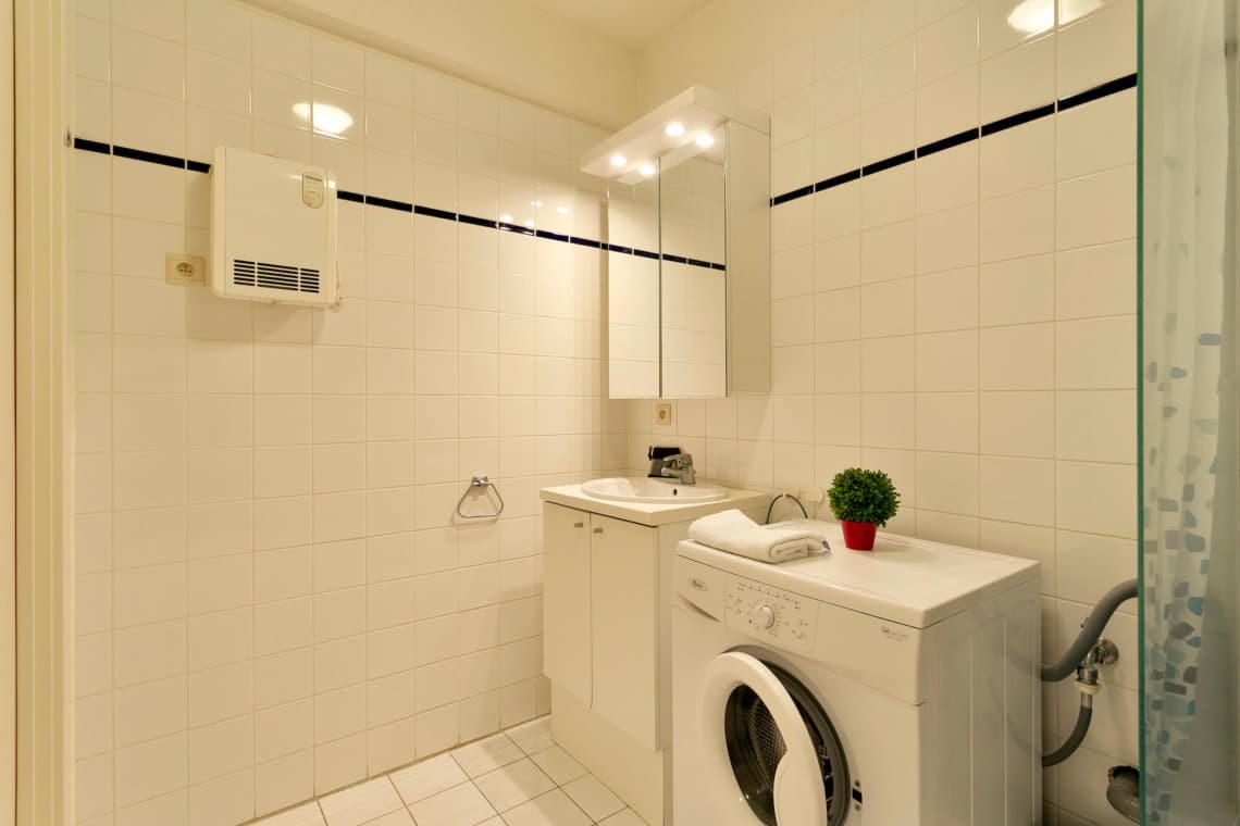 washing machine and bathroom with bathtub in bbf apartment in etterbeek