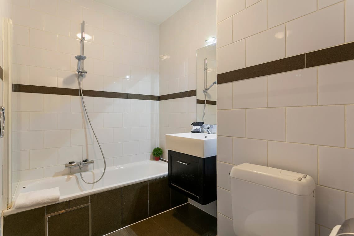 bathroom with bathtub in two bedroom apartment with towels and cleaning included