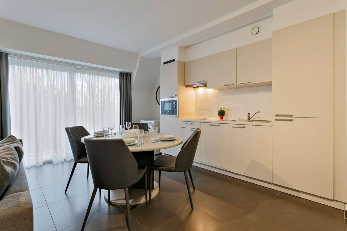 fully equipped kitchen in serviced apartment in west brussels with dining table and washing machine