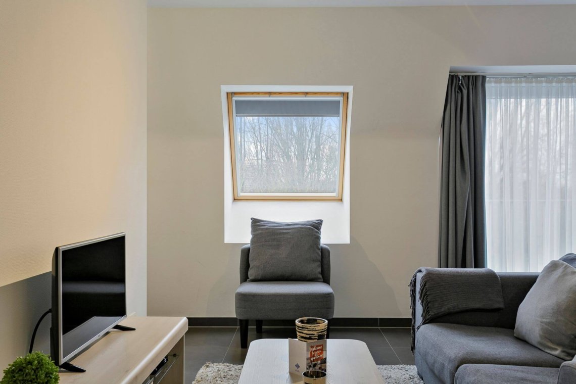 living room with sofa and coffee table with cable television