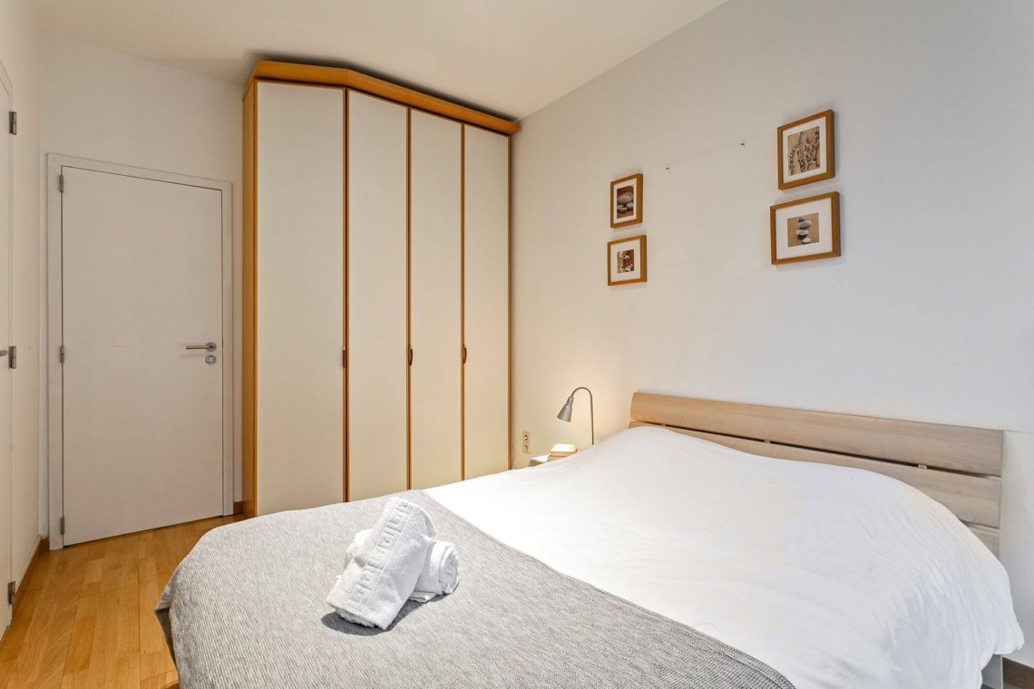 double bed in master bedroom with built in wardrobes near bois de la cambre