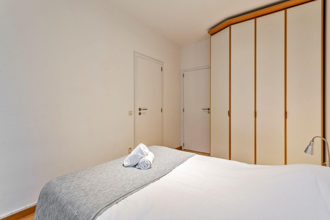 double bed in master bedroom with built in wardrobes near bois de la cambre