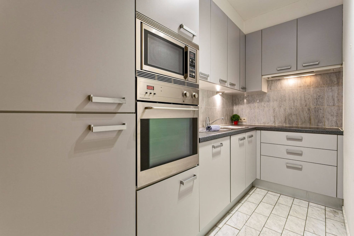 fully equipped kitchen with oven and microwave